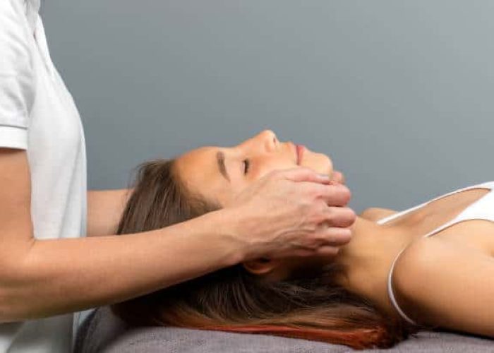 Close up of therapist doing osteopathic treatment on little girls chin.